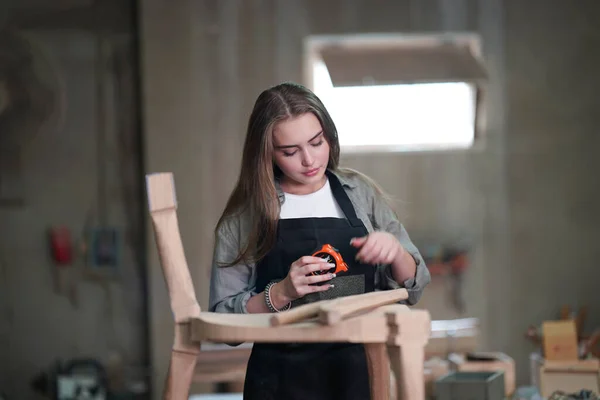 Small business of a young woman. Beautiful young woman worker in a furniture workroom