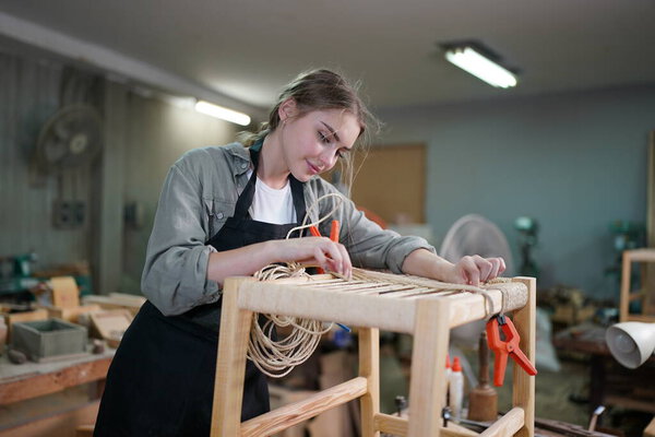 Small business of a young woman. Beautiful young woman worker in a furniture workroom