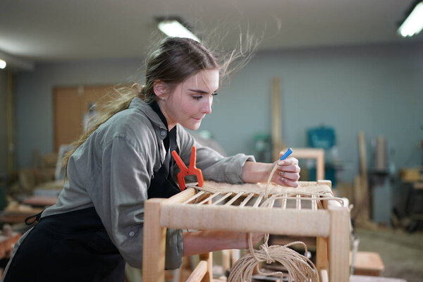 Small business of a young woman. Beautiful young woman worker in a furniture workroom