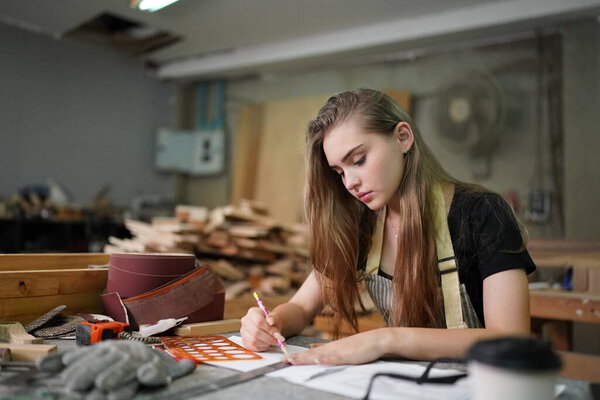 Small business of a young woman. Beautiful young woman worker in a furniture workroom