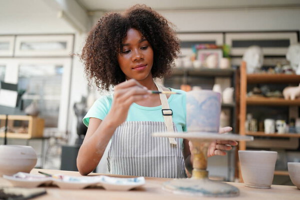 Young Afro girl in pottery workshop, Business owner