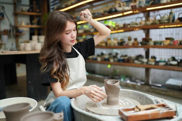 陶芸店に座っているエプロンの美しい職人のクローズアップ — ストック写真