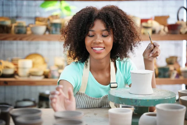 Young Afro girl in pottery workshop, Business owner