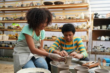 Genç Afro kız ve oğlan çömlek atölyesinde, işyeri sahibi.. 