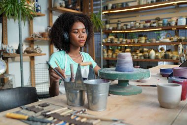 Çömlek atölyesindeki genç Afro kız, işyeri sahibi.. 