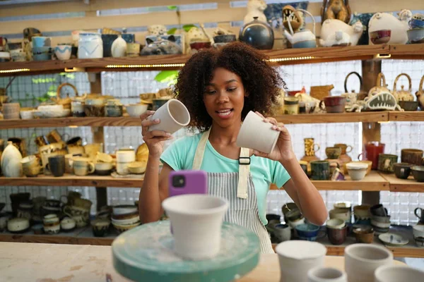 Young Afro girl in pottery workshop, Business owner