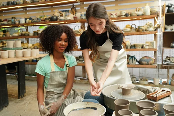 Young girls in pottery workshop, Business owner.