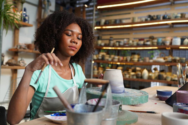 Young Afro girl in pottery workshop, Business owner