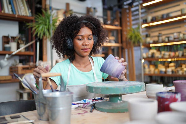Young Afro girl in pottery workshop, Business owner. 