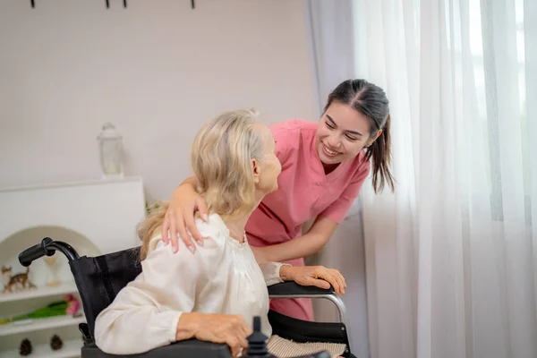 老年妇女和护士在家里 保健工作者的女孩关心家里的老年女性 — 图库照片