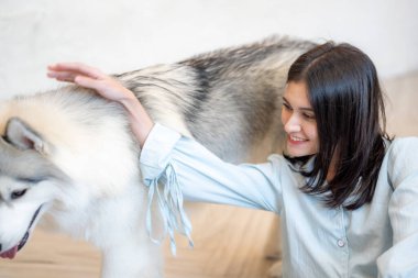 Evcil köpeği evde olan genç bir kadın.