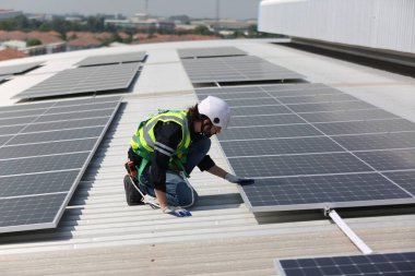 Teknoloji güneş pili, mühendislik servisi fabrikanın çatısındaki güneş pillerini kontrol ediyor. teknisyen güneş panellerinin bakımını kontrol ediyor