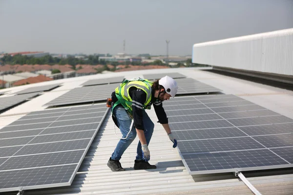 Technology solar cell, Engineer service checks installation solar cell on the roof of factory. technician checks the maintenance of the solar panels