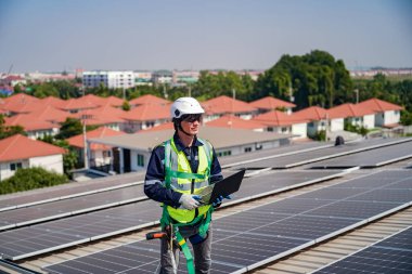 Teknoloji güneş pili, mühendis fabrikanın çatısındaki güneş pilini kontrol ediyor. teknisyen güneş panellerinin bakımını kontrol ediyor