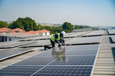 Teknoloji güneş pili, mühendis fabrikanın çatısındaki güneş pilini kontrol ediyor. teknisyen güneş panellerinin bakımını kontrol ediyor