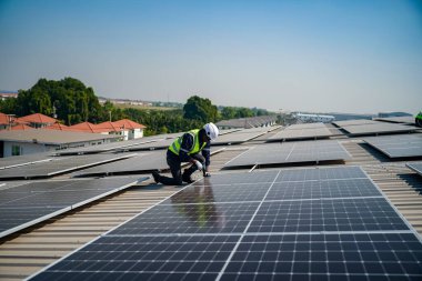 Teknoloji güneş pili, mühendis fabrikanın çatısındaki güneş pilini kontrol ediyor. teknisyen güneş panellerinin bakımını kontrol ediyor