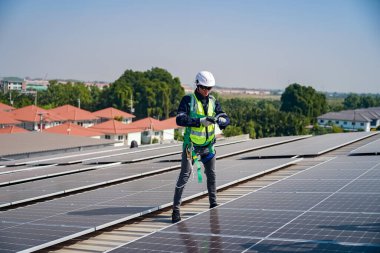 Teknoloji güneş pili, mühendis fabrikanın çatısındaki güneş pilini kontrol ediyor. teknisyen güneş panellerinin bakımını kontrol ediyor