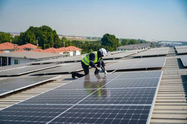 Teknoloji güneş pili, mühendis fabrikanın çatısındaki güneş pilini kontrol ediyor. teknisyen güneş panellerinin bakımını kontrol ediyor