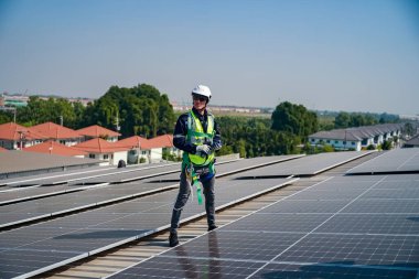 Teknoloji güneş pili, mühendis fabrikanın çatısındaki güneş pilini kontrol ediyor. teknisyen güneş panellerinin bakımını kontrol ediyor