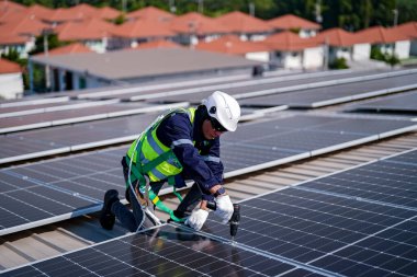 Teknoloji güneş pili, mühendis fabrikanın çatısındaki güneş pilini kontrol ediyor. teknisyen güneş panellerinin bakımını kontrol ediyor