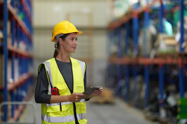 Depo Endüstriyel tedarik zinciri ve lojistik şirketleri içeride. Depo çalışanları envanteri kontrol ediyor. Envanter raflarındaki ürünler.