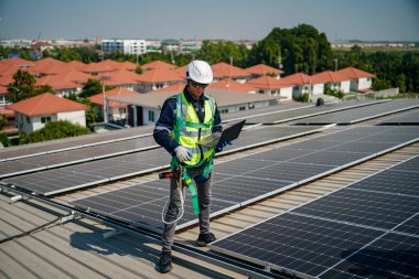 Teknoloji güneş pili, mühendislik servisi fabrikanın çatısında güneş pili kurulumunu kontrol ediyor. teknisyen güneş panellerinin bakımını kontrol ediyor