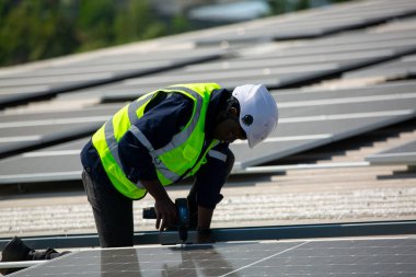 Teknoloji güneş pili, mühendis fabrikanın çatısındaki güneş pilini kontrol ediyor. teknisyen güneş panellerinin bakımını kontrol ediyor