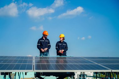 Teknoloji güneş pili, mühendislik servisi fabrikanın çatısında güneş pili kurulumunu kontrol ediyor. teknisyen güneş panellerinin bakımını kontrol ediyor