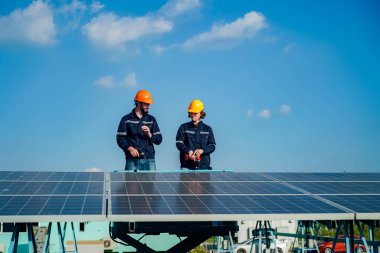 Teknoloji güneş pili, mühendislik servisi fabrikanın çatısında güneş pili kurulumunu kontrol ediyor. teknisyen güneş panellerinin bakımını kontrol ediyor