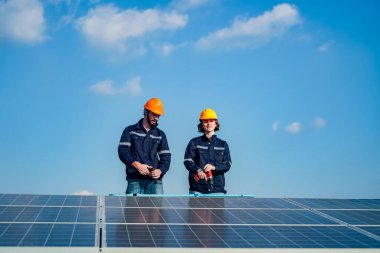 Teknoloji güneş pili, mühendislik servisi fabrikanın çatısında güneş pili kurulumunu kontrol ediyor. teknisyen güneş panellerinin bakımını kontrol ediyor