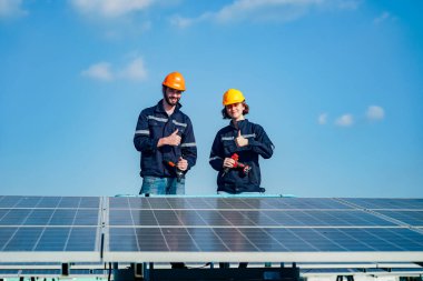 Teknoloji güneş pili, mühendislik servisi fabrikanın çatısında güneş pili kurulumunu kontrol ediyor. teknisyen güneş panellerinin bakımını kontrol ediyor