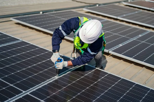 Teknoloji güneş pili, mühendislik servisi fabrikanın çatısında güneş pili kurulumunu kontrol ediyor. teknisyen güneş panellerinin bakımını kontrol ediyor