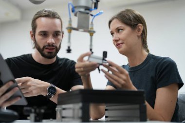 Genç adam ve kadın dijital tabletle çalışıyorlar.