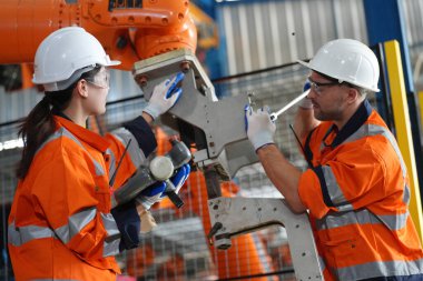 Mühendisler, akıllı fabrika otomotiv endüstrisindeki otomatik silah makinelerinin kaynak ve kontrol sistemlerini kontrol ediyorlar. Dijital üretim operasyonu. Sektör 4.0
