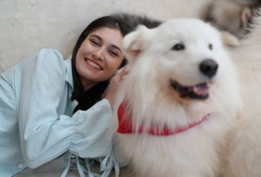 Neşeli kadın evinde köpeğiyle oynuyor..