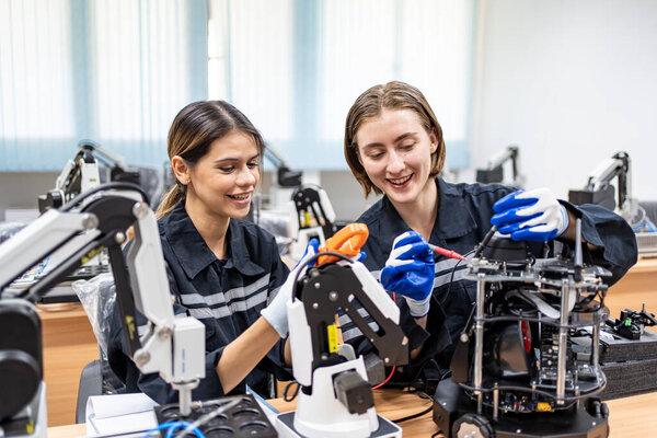 Engineers checking and controling welding robotics automatic arms machine in intelligent factory automotive industrial with monitoring system software. Digital manufacturing operation. Industry 4.0