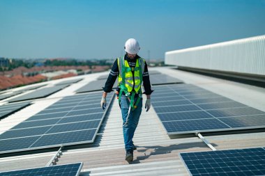 Makinist çatıya güneş panelleri kuruyor. Erkek mühendis çalışıyor. 
