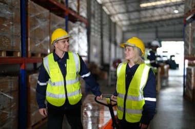 Büyük lojistik dağıtım deposunda çalışan depo çalışanları. Depoda çalışan yansıtıcı giysi işçisi.