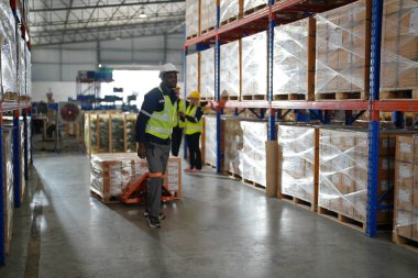 Büyük lojistik dağıtım deposunda çalışan depo çalışanları. Depoda çalışan yansıtıcı giysi işçisi.