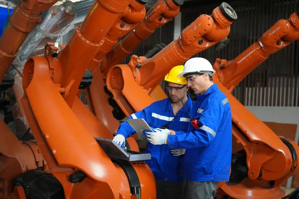 工程师检查和控制焊接机器人自动武器机在智能工厂汽车工业与监控系统软件 数字制造操作 行业4 — 图库照片