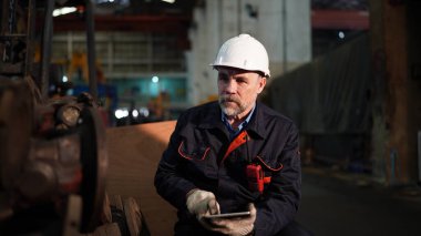 İnşaat alanında ya da ekipman bakım sahasında duran insan mühendisi.