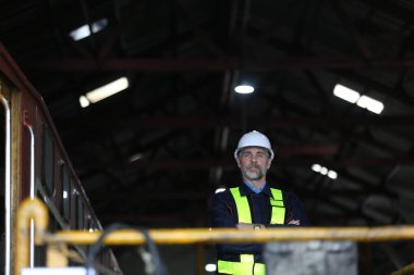 Fabrikadaki metro veya bakım ekipmanları şantiyesinde duran insan mühendisi