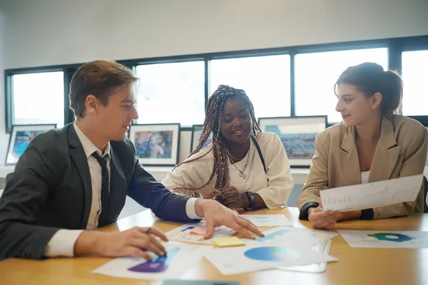 Image of young business people discussing document in paperwork data on desk at meeting