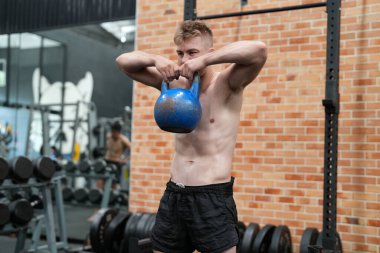 Spor salonunda ya da spor salonunda çapraz eğitim ekipmanları üzerinde egzersiz yapan genç aktif sporcu