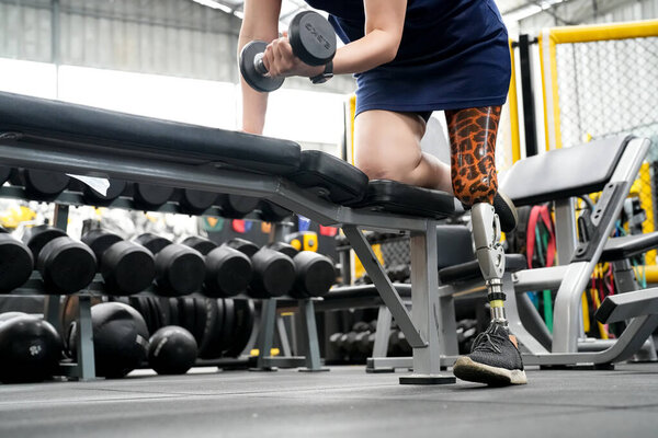 Portrait of disabled athlete woman with prosthetic leg in fitness gym