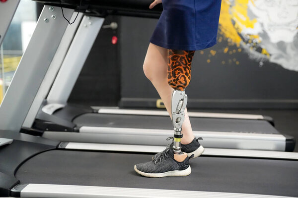 Портрет спортсменки-инвалида с протезом ноги в тренажерном зале