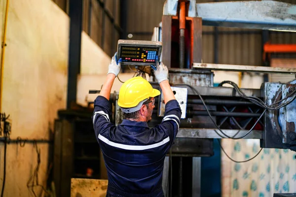 Stock image Lathe Operator Concentrated on Work. Worker in uniform and helmet works on lathe, factory. Industrial production, metalwork engineering, manufacturing.