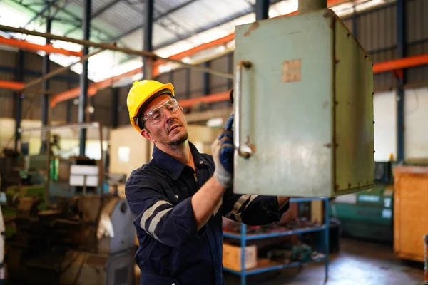 stock image Lathe Operator Concentrated on Work. Worker in uniform and helmet works on lathe, factory. Industrial production, metalwork engineering, manufacturing.