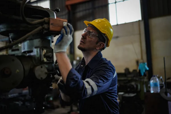 stock image Lathe Operator Concentrated on Work. Worker in uniform and helmet works on lathe, factory. Industrial production, metalwork engineering, manufacturing.