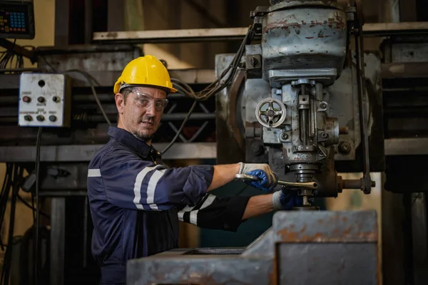 stock image Lathe Operator Concentrated on Work. Worker in uniform and helmet works on lathe, factory. Industrial production, metalwork engineering, manufacturing.